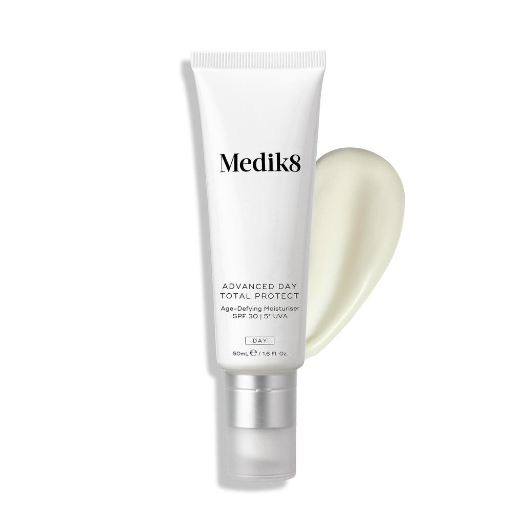 Een tube Medik8 Advanced Day Total Protect wordt getoond naast een draaiende swirl van lichte crème.