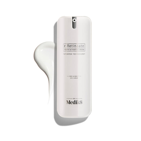Een witte pompflacon van r-Retinoate Day & Night Eye Serum, met daarnaast een druppel van het product.-1