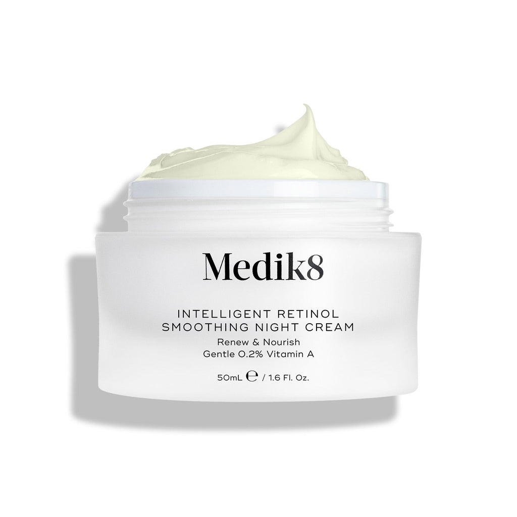Een afbeelding van de Intelligent Retinol Smoothing Night Cream-pot, open en met zichtbare crème, op een witte achtergrond.