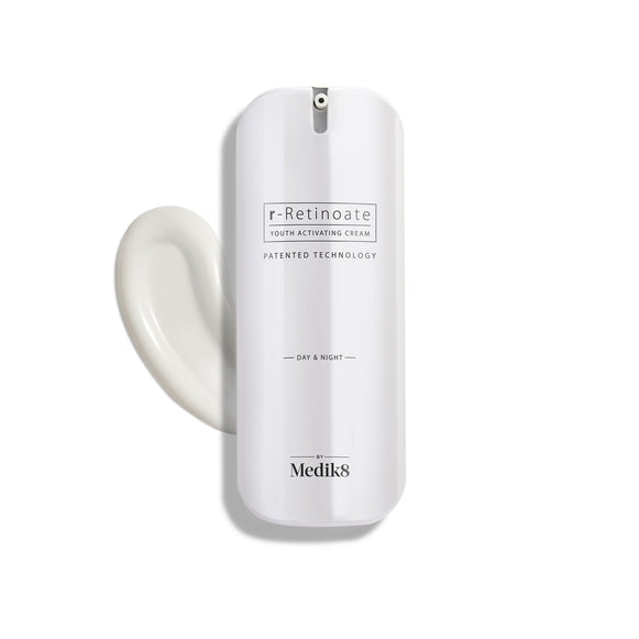 Een slanke witte pompflacon van r-Retinoate Day & Night staat rechtop, met daarnaast een sierlijke krul witte crème.-1