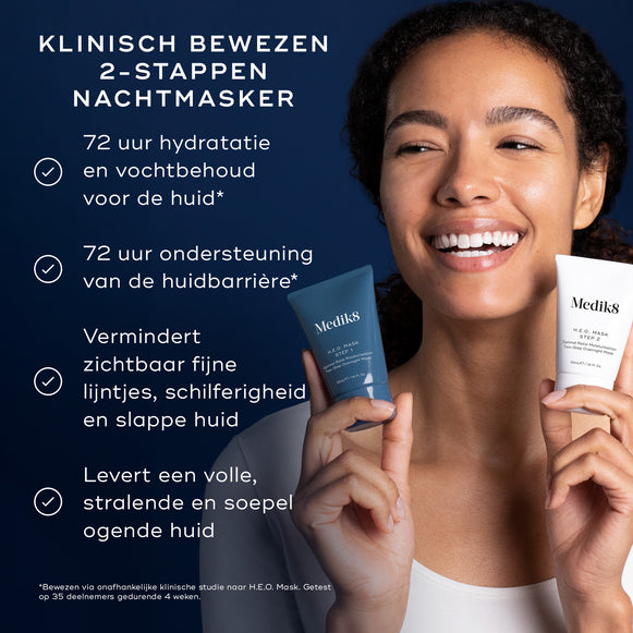 Een vrouw glimlacht terwijl ze de twee tubes van het Medik8 H.E.O. Mask vasthoudt (blauw Stap 1 en wit Stap 2). Tekst benadrukt het product als een KLINISCH BEWEZEN 2-STAPPEN NACHTMASKER met voordelen waaronder: 72 uur hydratatie en vochtbehoud van de huid, 72 uur ondersteuning van de huidbarrière, het zichtbaar verminderen van fijne lijntjes, schilfering en een crepey huidtextuur, en het zorgt voor een volle, stralende en soepele ogende huid.-hover-5