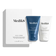 Een witte productverpakking voor het H.E.O.-masker staat naast twee tubes van het masker.