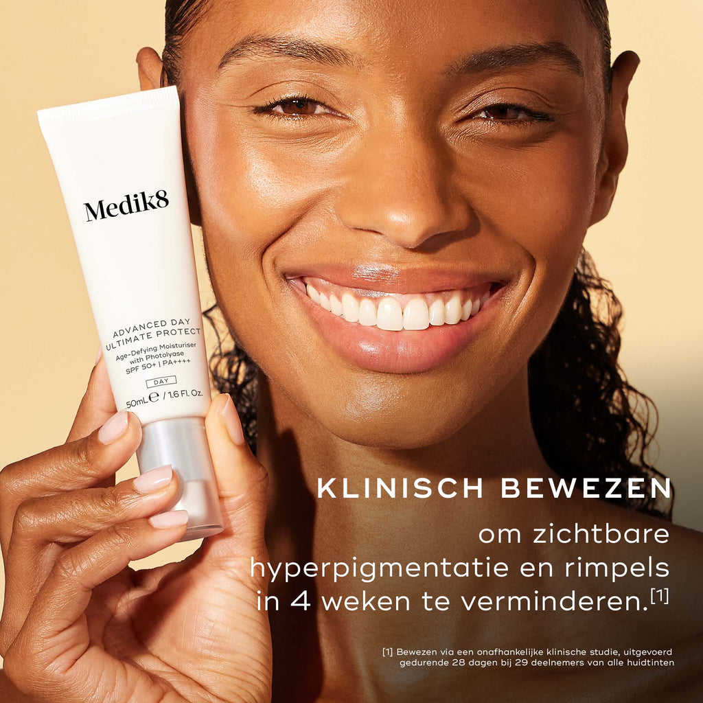 Close-up van een glimlachende vrouw met een stralende teint die een tube Advanced Day Ultimate Protect vasthoudt. De tekst vermeldt: "KLINISCH BEWEZEN om zichtbare hyperpigmentatie en rimpels te verminderen in 4 weken."