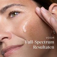 Close-up van een vrouw die Medik8-serum op haar wang aanbrengt, met tekst die verwijst naar full-spectrum resultaten.