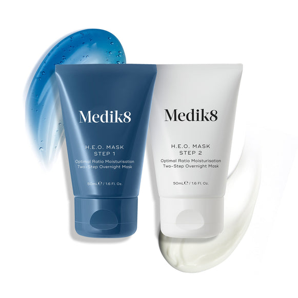 De twee tubes van het Medik8 H.E.O.-masker worden getoond: een blauwe tube voor stap 1 met een blauwe geltextuur, en een witte tube voor stap 2 met een witte crèmetextuur.-5